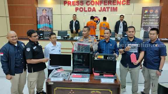Petugas kepolisian saat menunjukkan barang bukti yang digunakan untuk membobol website Pemprov Jatim dan ITS