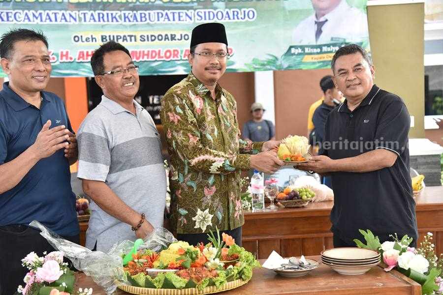 Bupati Sidoarjo Dorong Peningkatan Kualitas Pelayanan Publik di Kantor Desa Peresmian: Bupati Sidoarjo Gus Muhdlor serahkan potongan tumpeng ke Kades Kalimati Tarik