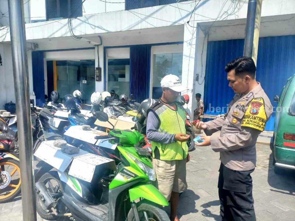 Polisi saat membagikan kunci ganda kepada juru parkir
