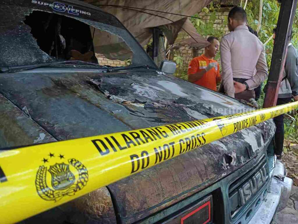 Petugas Inafis dari Polres Gresik melakukan penyelidikan terhadap mobil Isuzu Panther yang diduga dibakar orang tak dikenal