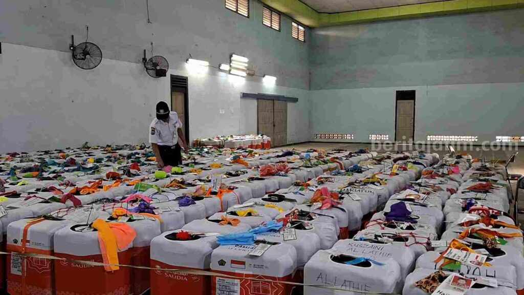 Petugas memeriksa koper CJH di aula Kantor Kemenag Kabupaten Mojokerto. [Foto : Misti/beritajatim.com]