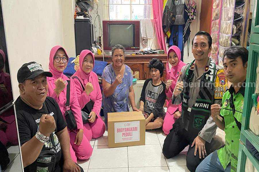Rayakan HUT Bhayangkara dan Persebaya, Polsek Simokerto dan Bonek Gelar Bakti Sosial Kapolsek Simokerto (dua dari kanan) bersama bhayangkari dan Bonek Mania saat memberikan bungkusan sembako di salah satu titik di Tambakrejo. Rabu (21/06/2023). (Foto/ist)