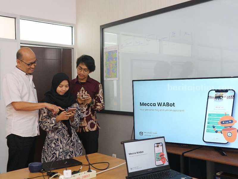 Ir Achmad Holil Noor Ali MKom mendemonstrasikan Mecca WABot melalui gawai