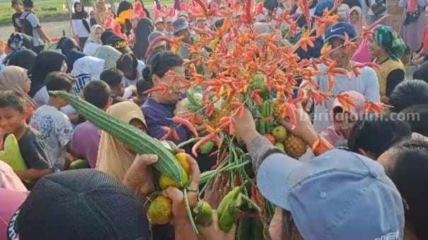 Warga Desa Sidorejo berebut gunungan aneka sayur mayur usai dikirab. [Foto : Misti/beritajatim.com]