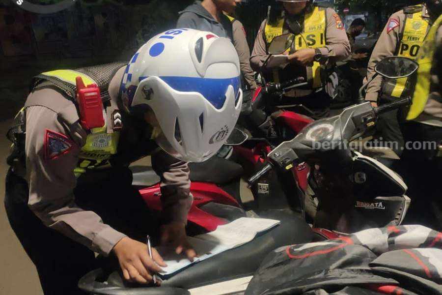 Tawuran Gangster Marak di Surabaya, Begini Antisipasi Polrestabes Petugas kepolisian saat melakukan tilang kepada pelanggar sepeda motor di wilayah Genteng, Jumat (02/05/2023) dini hari. (Foto/ist)