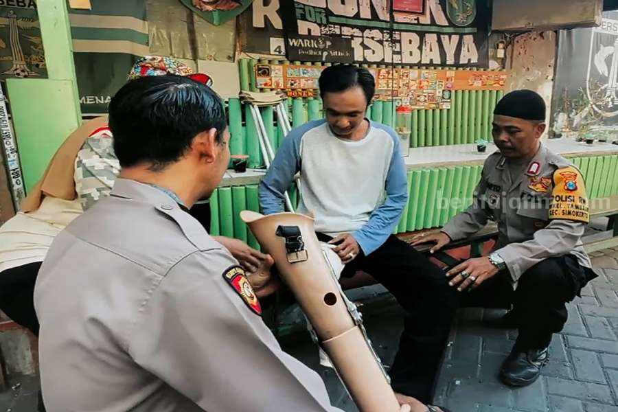 Kapolsek Simokerto, Kompol Dwi Nugroho saat memberikan kaki palsu ke Rudiono. (Foto/Anggadia)