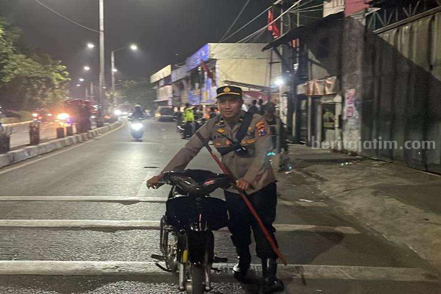 Petugas Kepolisian saat mengamankan sepeda motor tanpa surat di Jalan Kedung Cowek, Minggu (11/06/2023). (Foto/anggadia)