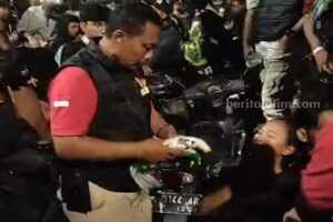 Anggota Satreskrim Polrestabes Surabaya usai melakukan pertolongan pertama pada Bonita yang pingsan saat mengikuti acara Ulang Tahun Persebaya di Jalan Tambaksari, Minggu (18/06/2023).
