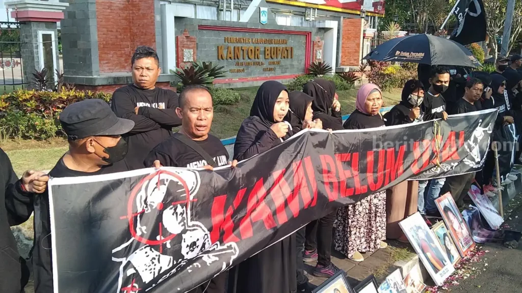 Demo Kantor Bupati Malang, Keluarga Korban Anggap Ada Pembantaian di Tragedi Kanjuruhan Aksi Pocong di unjuk rasa menuntut keadilan dari keluarga korban Tragedi Kanjuruhan di Depan Kantor Bupati Malang di Jalan Raya Panji, Kepanjen, Kabupaten Malang, Kamis (22/6/2023).