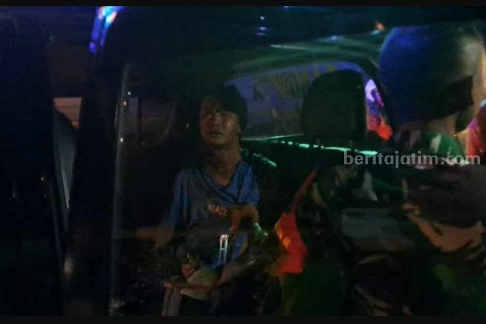 Pelaku pencurian saat diamankan oleh TNI/Polri usai dihajar massa. [Foto:Diah Ayu/beritajatim.com]