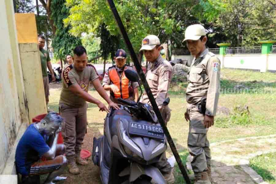 Petugas Satpol PP Tuban saat mengamankan manusia silver. [Foto:Diah Ayu/beritajatim.com]