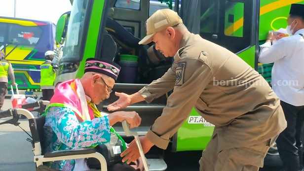 Petugas Satpol PP Jombang membantu kakek Rifai naik ke atas bus saat di pendapa setempat, Selasa (20/6/2023). [Foto/Yusuf Wibisono]