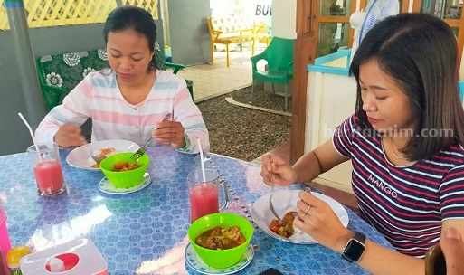 Dua orang pembeli sedang menikmati tongseng kambing Kendedes Resto Jombang, Senin (19/6/2023)