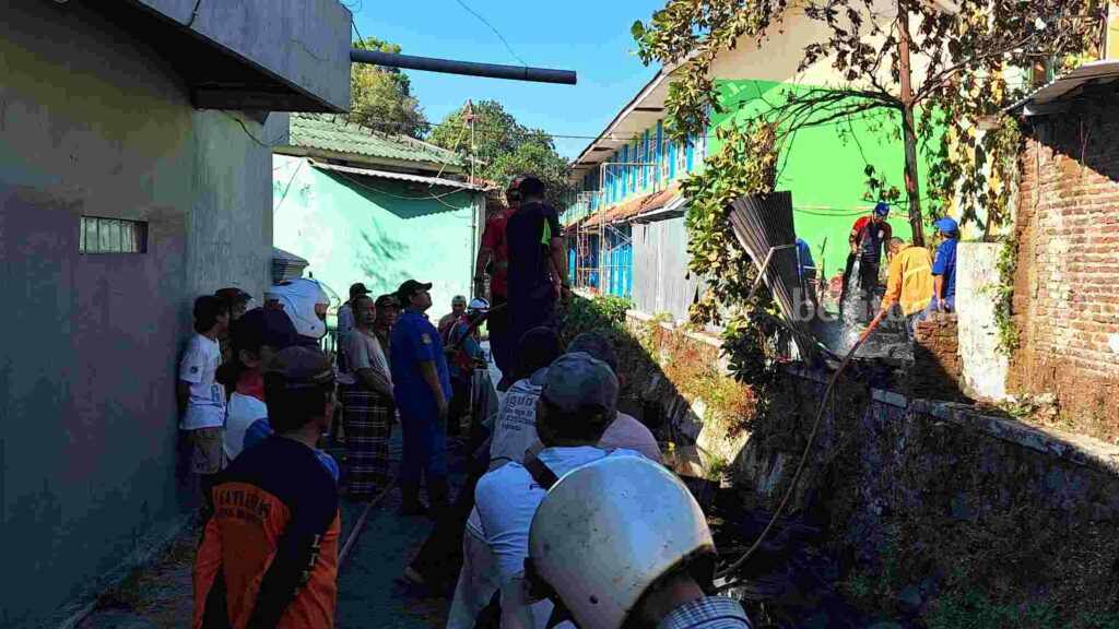Petugas Damkar Kota Mojokerto melakukan upaya pemadamkan di lokasi kebakaran. [Foto : Misti/beritajatim.com]