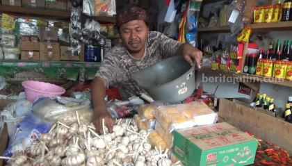 Pedagang di pasar Legi Kota Blitar sedang mengemas bawang putih.