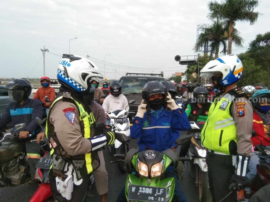 Polisi saat menegur pengendara roda agar mengenakan helm dengan benar