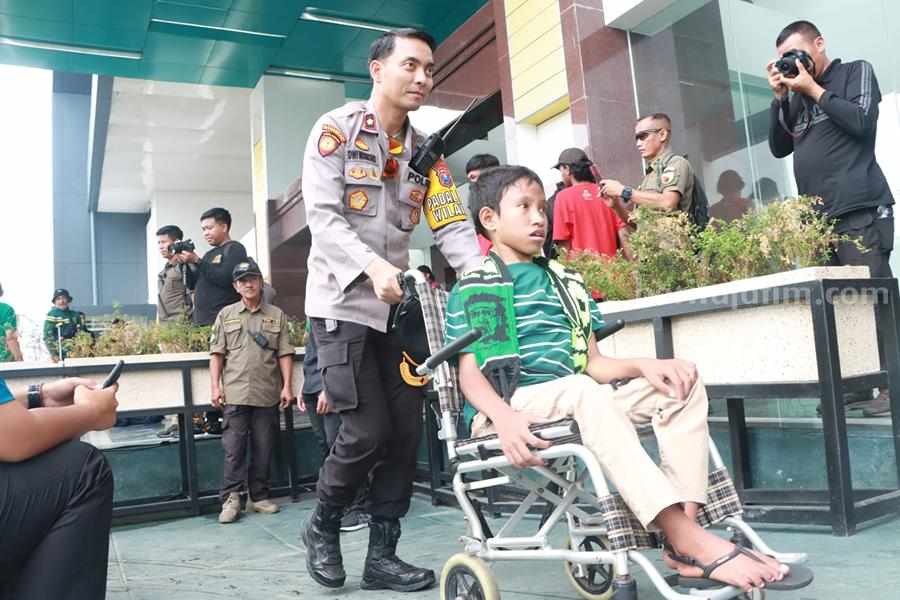 Kapolsek Simokerto, Kompol Dwi Nugroho saat mengantarkan salah satu disabilitas ke Gate khusus di Stadion Gelora Bung Tomo, Minggu (09/07/2023). (Foto/polsek simokerto for Beritajatim.com)