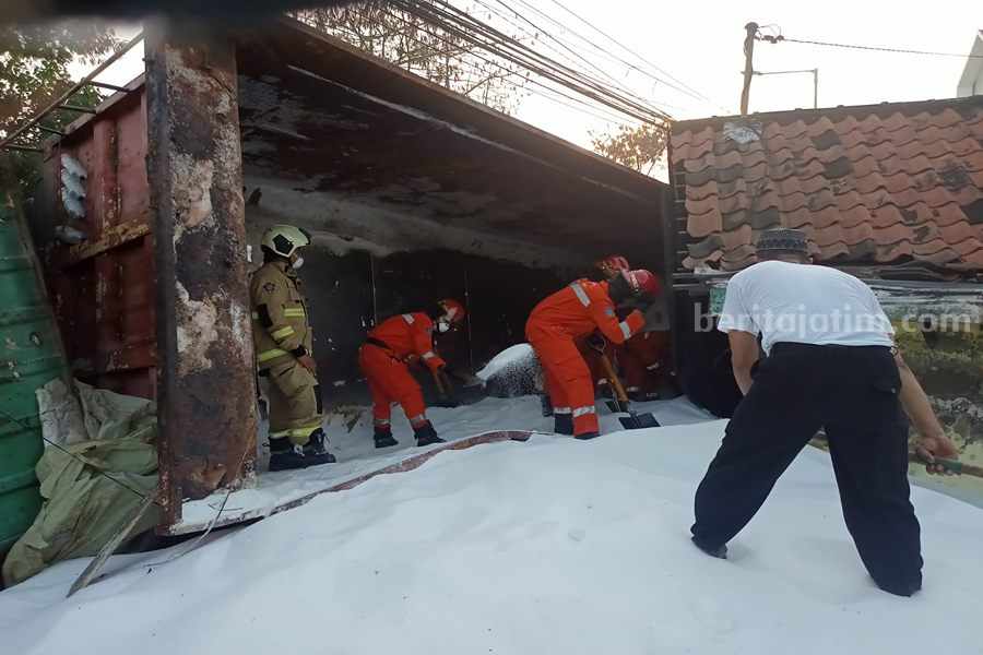 Polisi Amankan Pengemudi Truk Pupuk Terguling di Surabaya Petugas gabungan dari BPBD Kota Surabaya dan Damkar saat membersihkan Pupuk Urea yang tercecer di Jalan Greges Barat, Minggu (09/07/2023). (Foto/ist).
