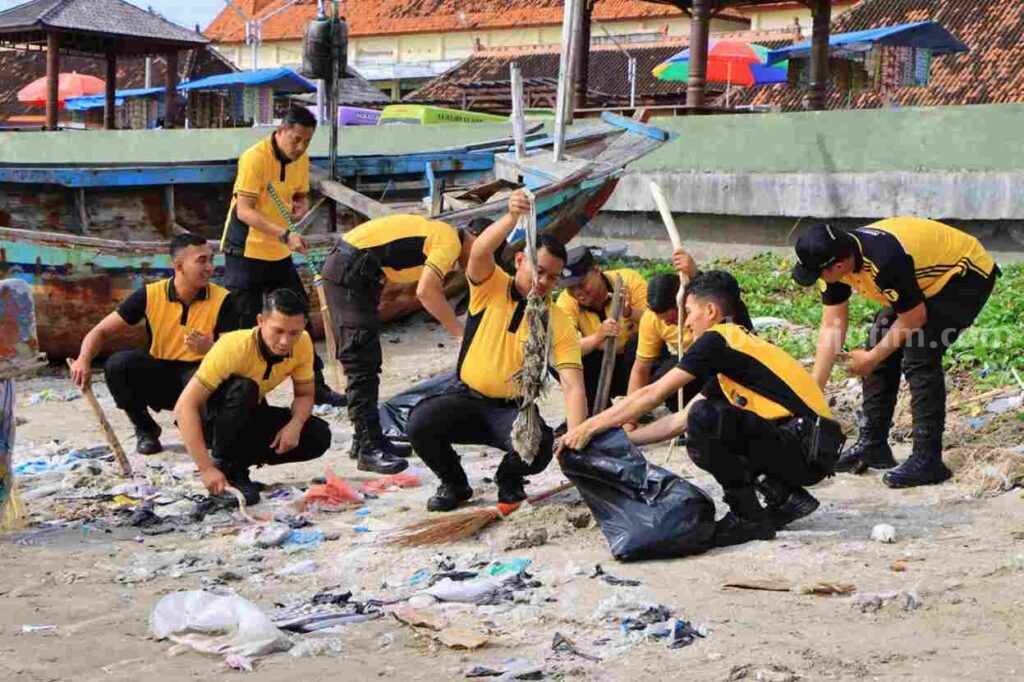 Personel dari Polres Tuban saat melakukan bersih - bersih pantai Boom Tuban. [Foto:Diah Ayu/beritajatim.com]