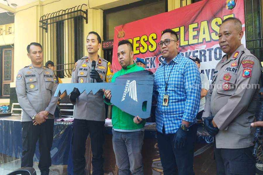 Andre (baju hijau) saat penerimaan simbolik pengembalian sementara di Polsek Simokerto.