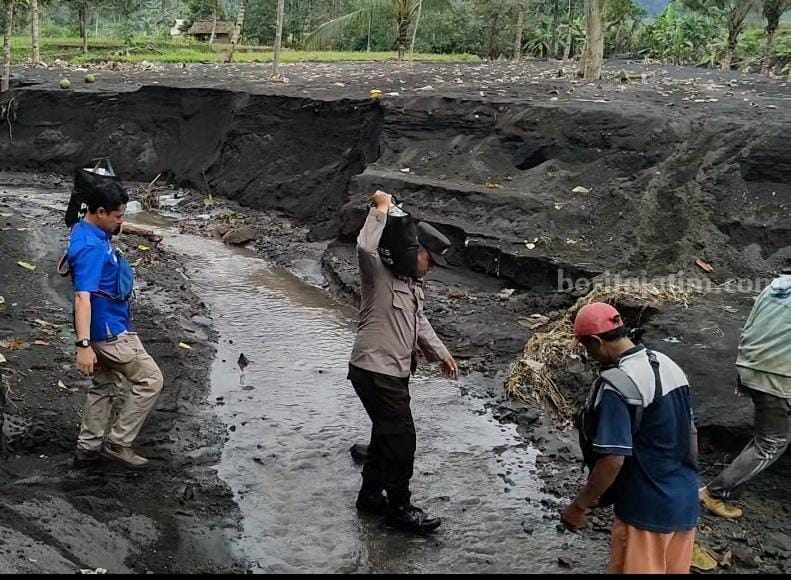 Anggota Polres Malang, harus berjalan sejauh 2,7 kilometer menuju desa Purwoharjo, Kecamatan Ampelgading, Kabupaten Malang yang terisolir dampak banjir lahar dingin gunung semeru, Minggu (15/7/2023).
