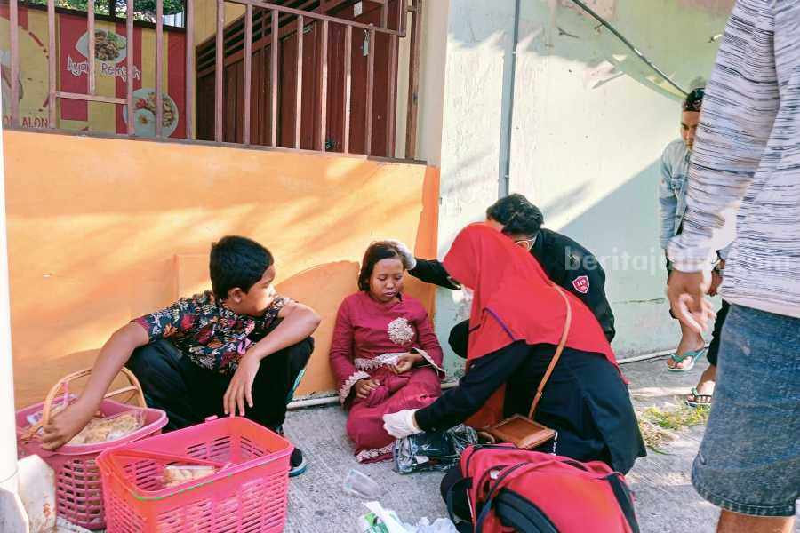 Kakak beradik Dinda dan Krisna pedagang asongan saat diberikan pertolomgan oleh tim kesehatan usai ditabrak pemotor. Senin (17/07/2023).