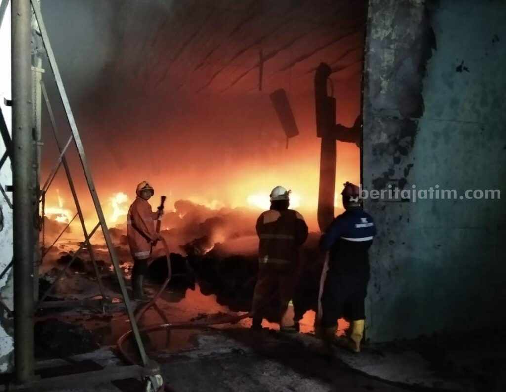 Petugas dari Damkar BPBD Kabupaten Mojokerto melakukan pemadaman di pabrik benang untuk pembuatan sarung tangan. [Foto : ist]