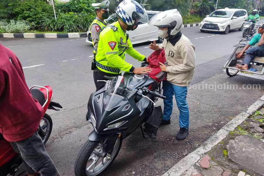 Anggota Satlantas Polrestabes Surabaya saat menindak salah satu pengendara motor yang tidak memasang plat nomor. (Foto/humas Polrestabes Surabaya)