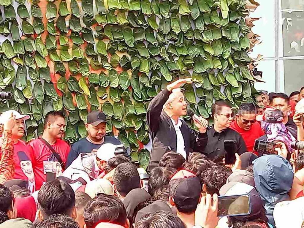 Capres Ganjar Pranowo (jas hitam) saat membagikan nasi krawu kepada ribuan masyarakat di Stadion Gelora Joko Sanudro