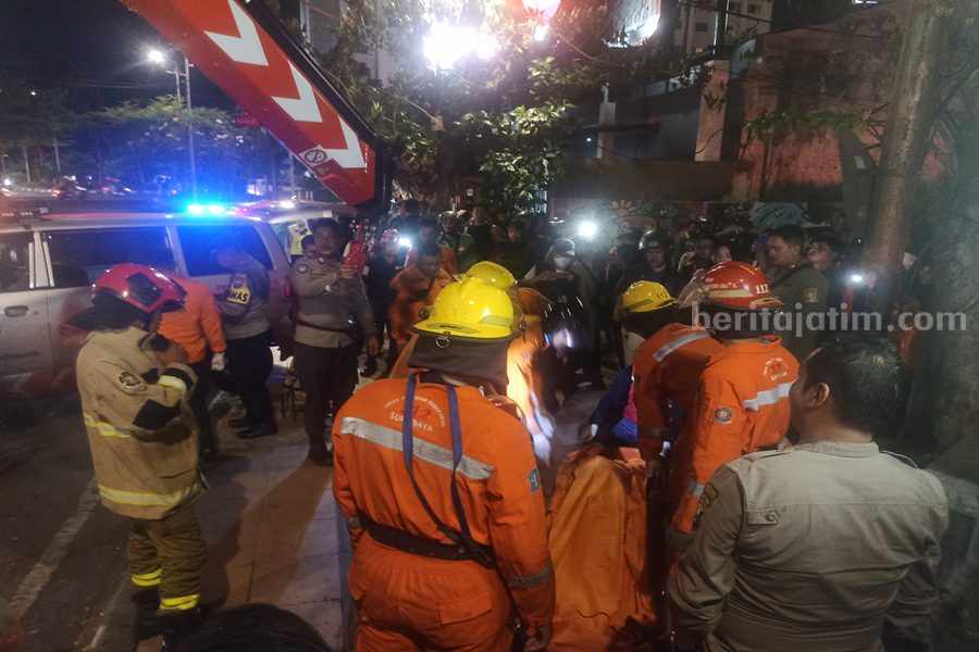 Petugas dari damkar dan BPBD Kota Surabaya saat mengevakuasi jenazah Ludfi di jembatan Jalan Pemuda, Rabu (25/07/2023) malam. (Foto/Anggadia)