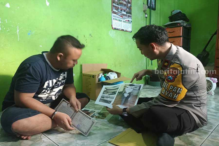 Andre (31) bersama dengan Kapolsek Simokerto, Kompol Dwi Nugroho ketika di rumah Jalan Kapas Jaya gang Buntu, Kamis (06/07/2023) sore. (Foto/Anggadia).