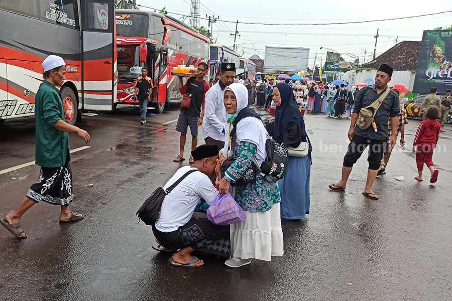 Salah satu penjemput mencium tangan keluarganya yang baru tiba dari tanah suci. (Foto/Endra Dwiono/Beritajatim.com)