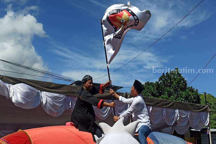 Ketua KPU Ponorogo Munajat menerima bendera KPU dari Ketua KPU Trenggalek Gembong Derita Hadi. (Foto/Endra Dwiono/Beritajatim.com)