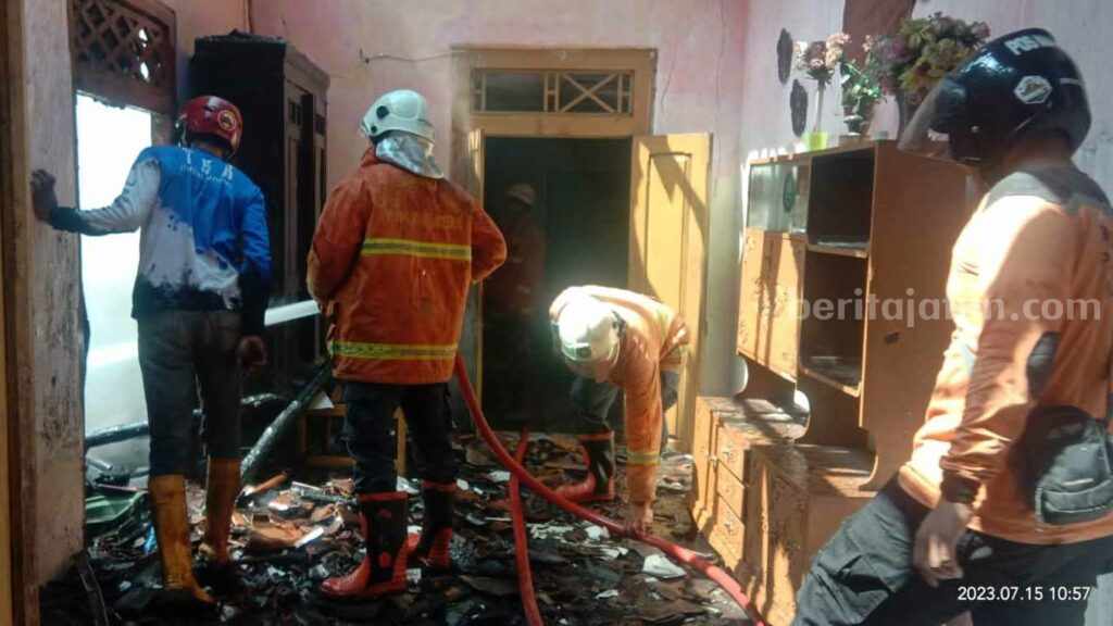 Petugas berupaya memadamkan api yang membakar rumah milik Niswatin. [Foto : ist]