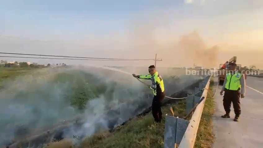 Petugas Unit 3 PJR Polda Jawa Timur melakukan pemadaman di area lahan kering yang terbakar. [Foto : ist]