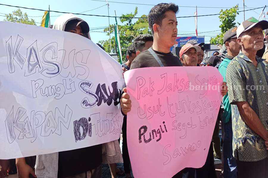 Minta Kejelasan Kejari Ponorogo Soal Kasus Pungli di Desa Sawo, Warga Bawa Poster Tulisan Menggelitik Poster dengan tulisan menggelitik yang dibawa oleh warga Desa Sawoo saat menggeruduk Kejari Ponorogo. (Foto/Endra Dwiono/Beritajatim.com)