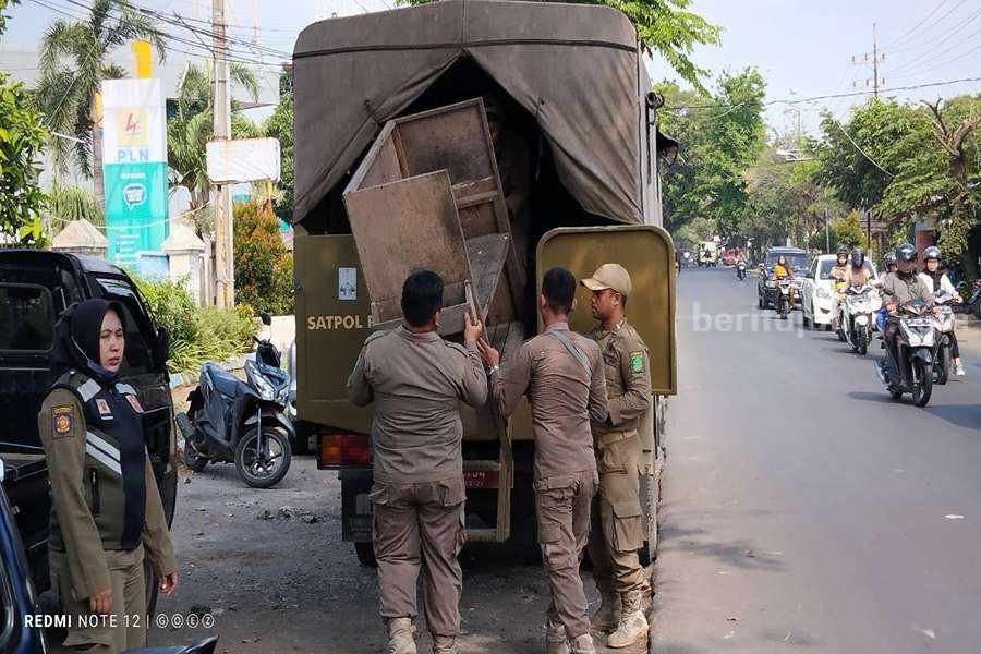 Satpol PP Kabupaten Pasuruan Tertibkan PKL Pasar Bangil Petugas Satpol PP Kabupaten Pasuruan saat mengangkat gerobak pedagang.
