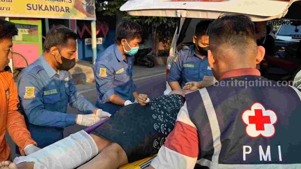 Penumpang sepeda motor Suzuki Satria tanpa nopol, Hartatik (26) saat dievakuasi sejumlah relawan ke mobil ambulance. [Foto : Misti/beritajatim.com]