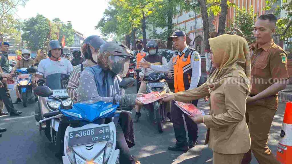 Wali Kota Mojokerto Ika Puspitasari membagikan bendera merah putih ke pengguna jalan. [Foto : Misti/beritajatim.com]
