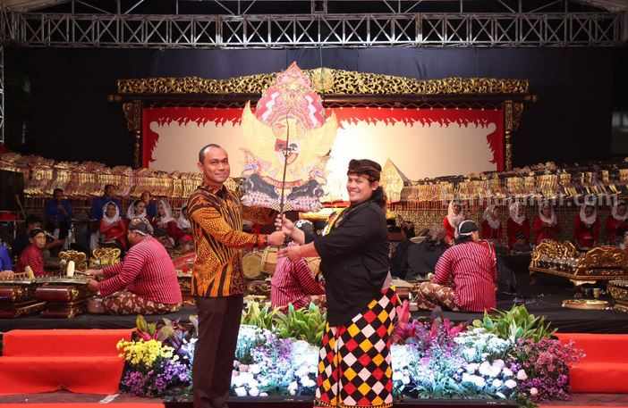 Kapolres Malang AKBP Putu Kholis Aryana, menyerahkan Gunungan, simbol di mulainya pagelaran Wayang Kulit bersama Ki Dalang Ardi Poerboanton.