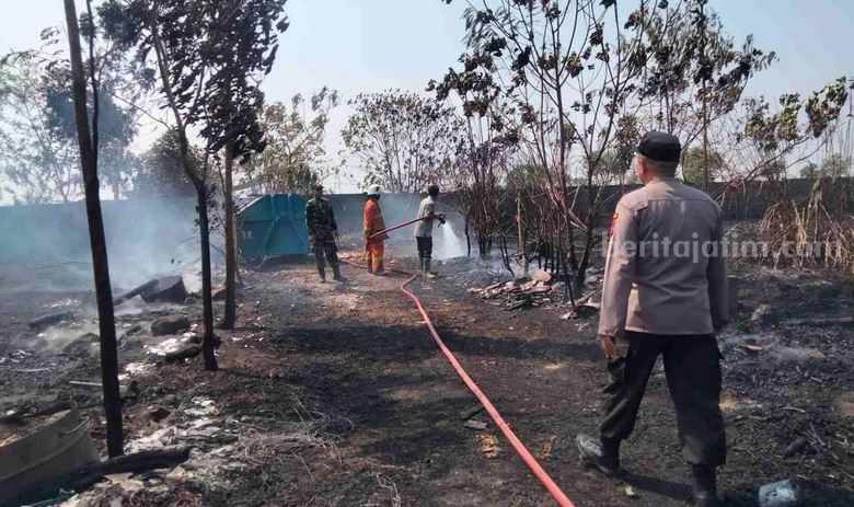Petugas damkar saat memadamkan lahan di belakang SMKN 1 Mojoanyar, Kecamatan Mojoanyar, Kabupaten Mojokerto. [Foto