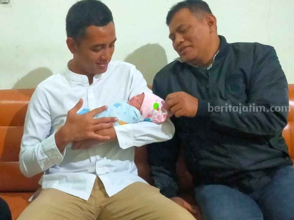 Kapolsek Baureno Ipda Suiswanto mendampingi Camat Baureno sedang menggendong bayi yang diduga dibuang ibunya di tepi jalan