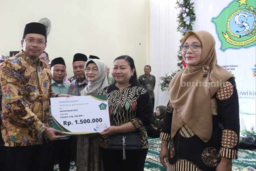 Simbolis, Bupati Sidoarjo Gus Muhdlor menyerahkan insentif kepada salah kader kesehatan.