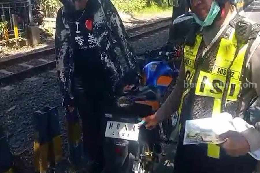 Ngefans Leonardo Da Vinci, Pengendara Motor di Surabaya Pasang Plat Nomor Monalisa Agus Salim saat menilang sepeda motor berplat Monalisa di Jalan Ahmad Yani, Senin (31/08/2023). (Foto/ist).