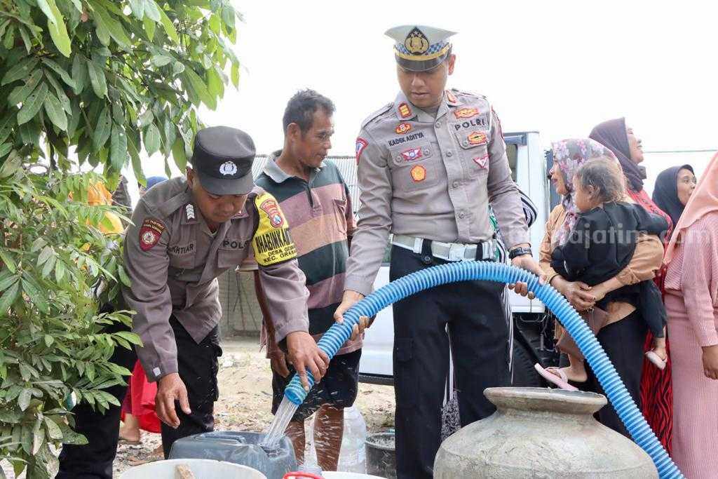 Kasat Lantas AKP Kadek Aditya Yasa Putra saat melakukan pendistribusian air bersih. [Foto:Diah Ayu/beritajatim.com]