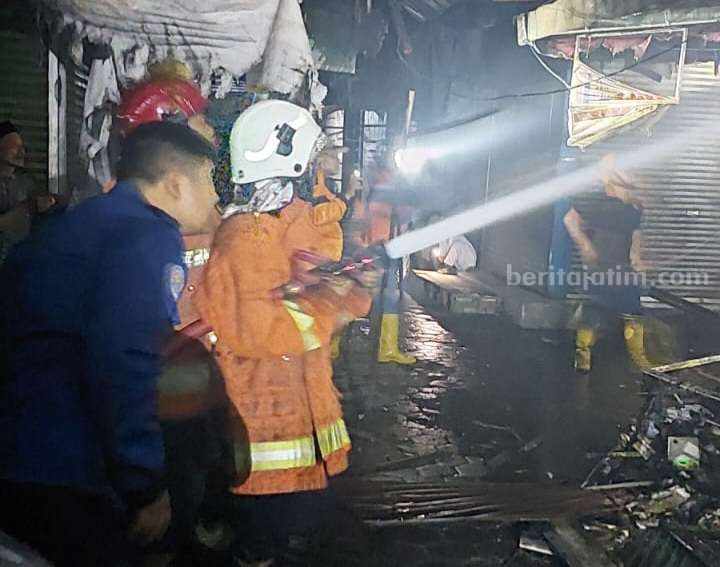 Petugas Damkar BPBD Kabupaten Mojokerto melakukan pemadaman di kios baju dan peralatan sekolah di Pasar Raya Mojosari, Desa Seduri, Kecamatan Mojosari, Kabupaten Mojokerto. [Foto : ist]
