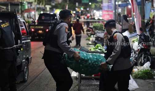 Anggota Polres Blitar Kota mengangkat dagangan yang berada di jalan Raya