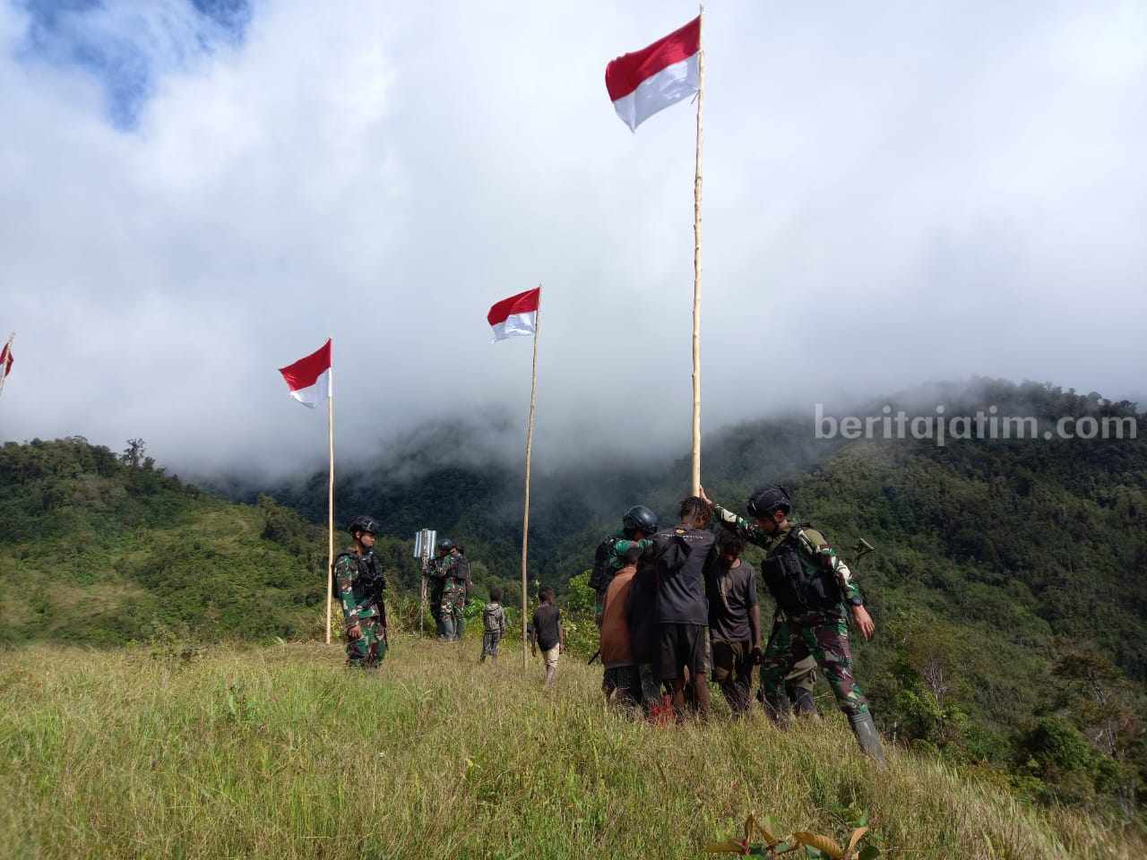 Personel Satgas Pamtas Mobile Yonif Para Raider 433/JS Kostrad mengajak anak-anak serta pemuda untuk memasang Bendera Merah Putih disekitar lingkungan Pos wilayah Distrik Yigi, Kabupaten Nduga, Papua.