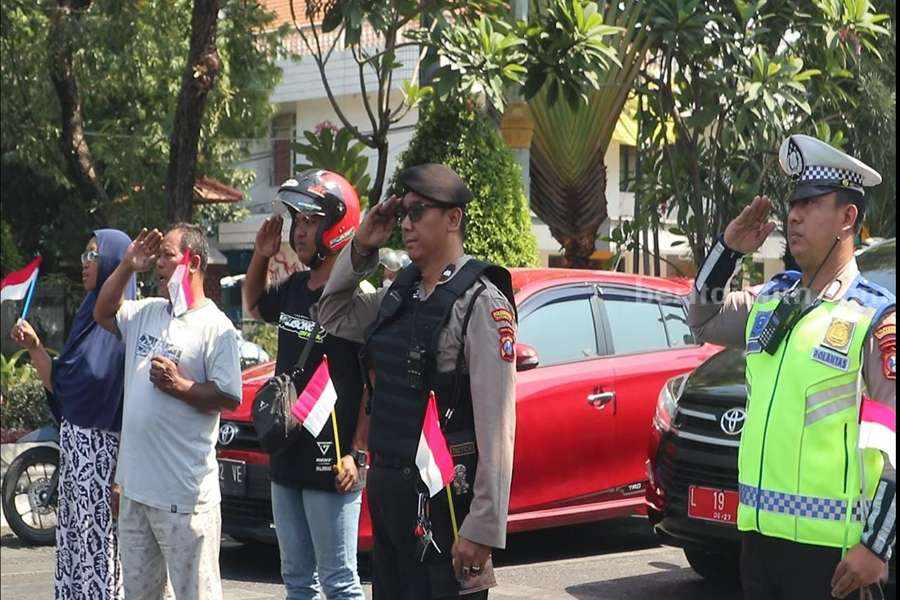 Polrestabes Surabaya Ajak Pengendara Jalan Nyanyikan Indonesia Raya di Darmo Pengendara jalan dan petugas kepolisian melakukan penghormatan saat pengibaran bendera merah putih di Simpang 4 Jalan Darmo-Polisi Istimewa, Kamis (17/08/2023). (Foto/ist).