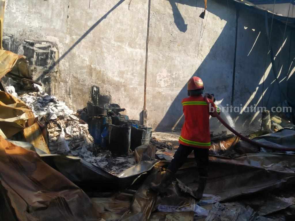 Petugas damkar berjibaku memadamkan api yang menghanguskan gudang di Jalan Raya Desa Cangkir Driyorejo Gresik